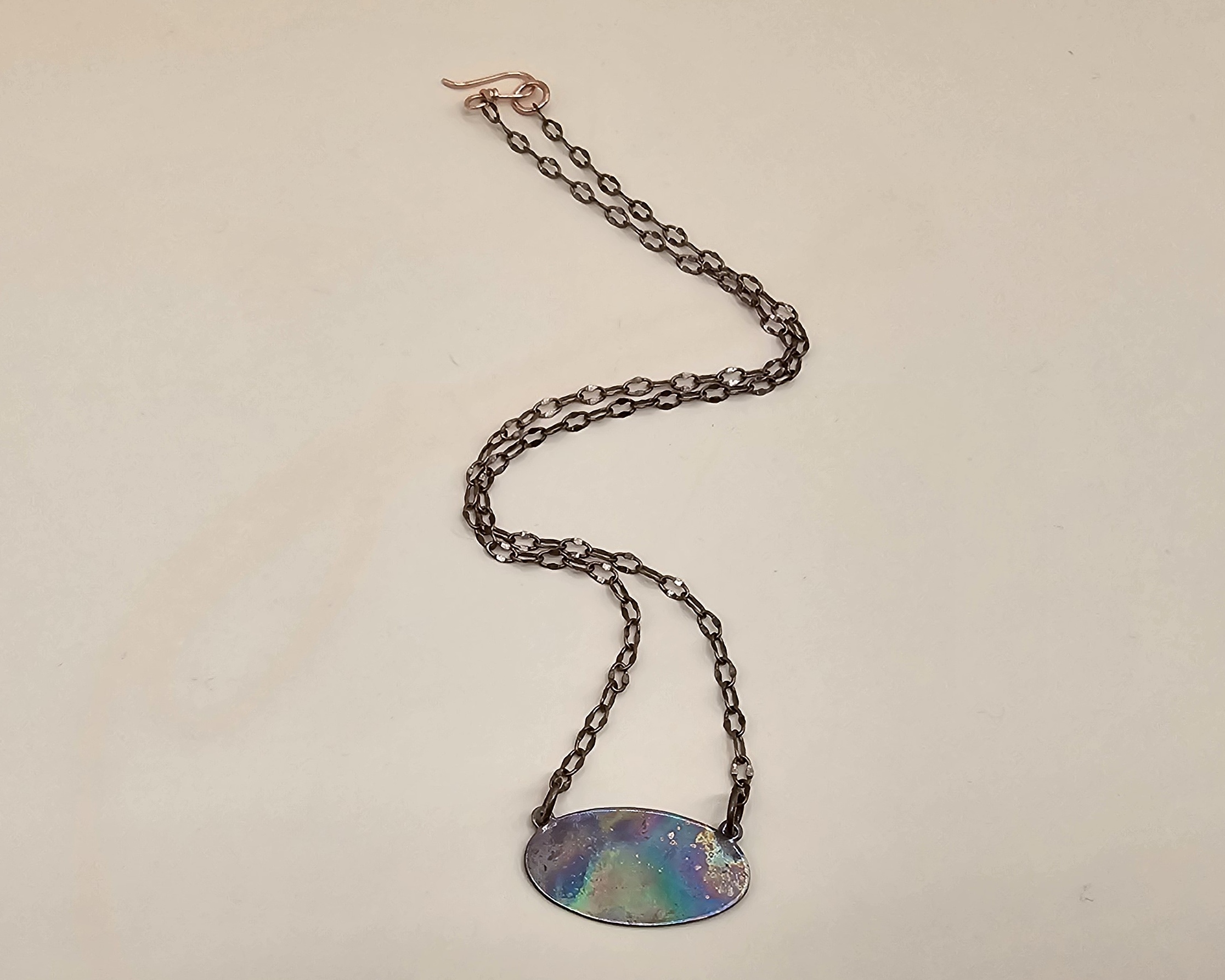 Handmade 16-inch copper necklace with flame-colored oval copper pendant in iridescent rainbow hues, hook clasp and copper chain. Handmade 16-inch copper necklace with flame-colored oval copper pendant in iridescent rainbow hues, hook clasp and copper chain.